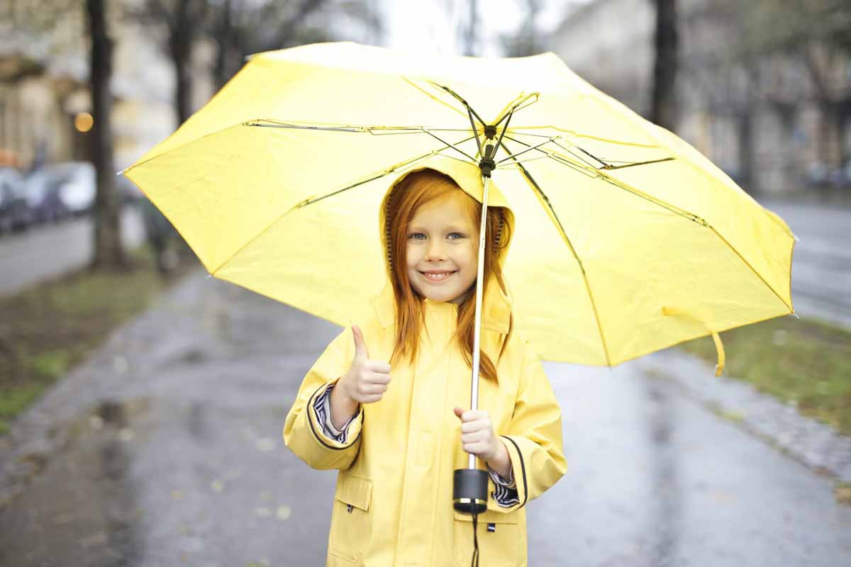 photo-of-smiling-girl-in-yellow-raincoat-holding-a-yellow